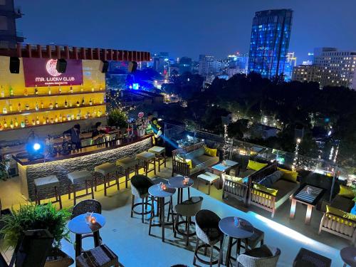 vista su un bar all'ultimo piano con tavoli e sedie di Happy Life Grand Hotel & Rooftop Skybar ad Ho Chi Minh