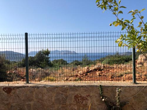 uma cerca com vista para o oceano atrás dela em Derya Beach Apartment em Kas