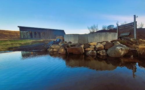 a bench sitting next to a body of water at Basalt Hotel in Borgarnes