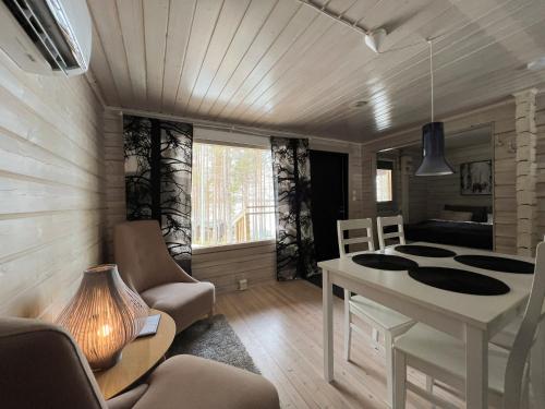 a room with a table and chairs and a bedroom at LakeLodge Kiehinen & Igloos in Rovaniemi