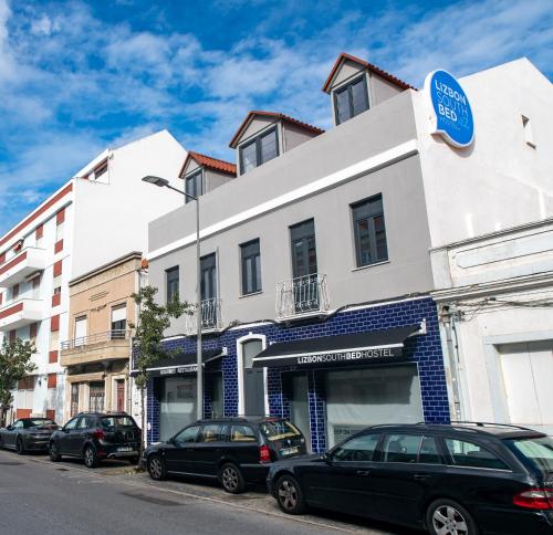 eine Straße mit Autos, die vor einem Gebäude geparkt sind in der Unterkunft Lizbon South Bed in Barreiro