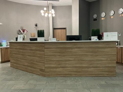 een lobby met een grote houten bar met klokken bij Wyndham Garden North Bergen - Secaucus in North Bergen