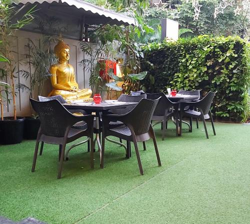 une table et des chaises avec une statue d'un buddha dans l'établissement Quality Inn Mint, à Pune