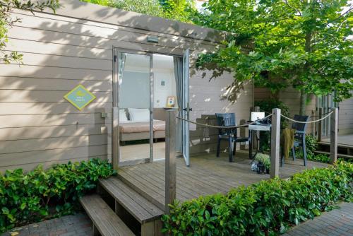 una terrazza in legno con porta in vetro e tavolo di hu Roma Camping In Town a Roma