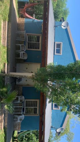 a blue and white building with trees in front of it at Los manzanos . in Colón