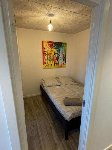 een bed in een kamer met een schilderij aan de muur bij RE-Seapark in Hvidovre