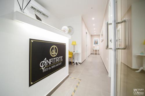 a white hallway with a sign on a wall at Anfitrite B&B Tropea in Tropea