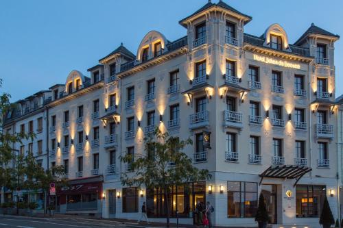 un grand bâtiment blanc au coin d'une rue dans l'établissement Jehan De Beauce - Teritoria, à Chartres