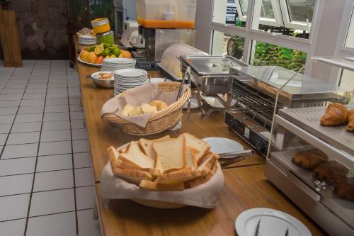 - une cuisine avec du pain et des viennoiseries sur un comptoir dans l'établissement Hôtel Bois Joli, à Terre-de-Haut