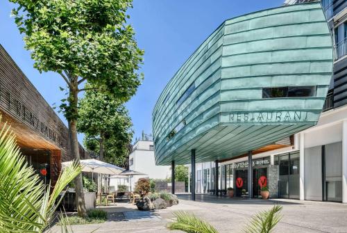 ein Gebäude mit einer Glaskuppel auf einer Straße in der Unterkunft Vienna House by Wyndham Martinspark Dornbirn in Dornbirn