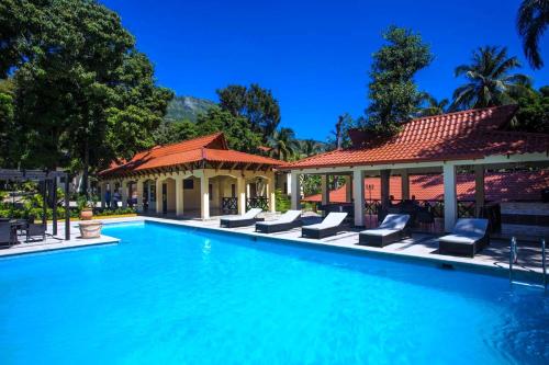 una piscina con sillas y un cenador en Auberge Villa Cana, en Cabo Haitiano