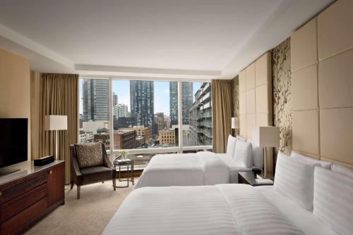 um quarto de hotel com duas camas e uma grande janela em Shangri-La Toronto em Toronto