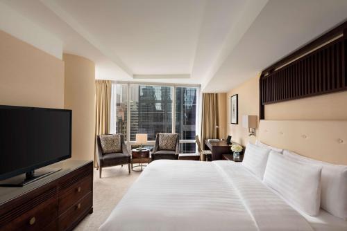 um quarto de hotel com uma cama e uma televisão de ecrã plano em Shangri-La Toronto em Toronto