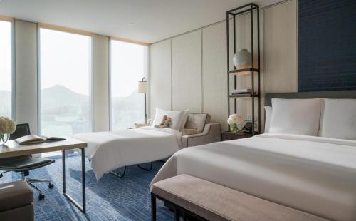 um quarto de hotel com duas camas e uma cadeira em Four Seasons Hotel Seoul em Seul