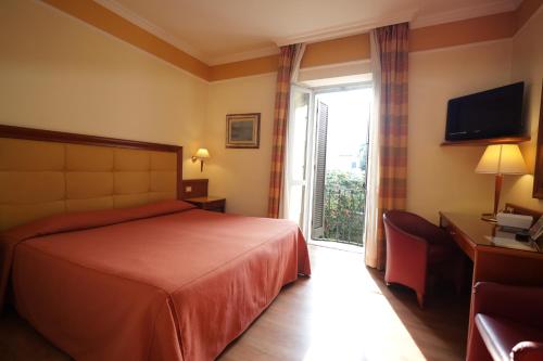 a hotel room with a bed and a window at Hotel Il Chiostro by LVG Hotel Collection in Verbania