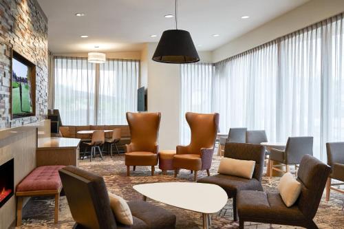 een wachtkamer met stoelen en tafels en een open haard bij Residence Inn By Marriott Dallas By The Galleria in Dallas