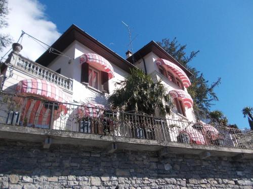 a white house with a balcony on a building at Villa Varenna in Varenna