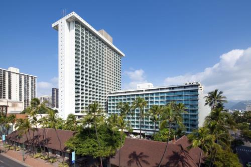 a tall white building with palm trees in front of it at Sheraton Princess Kaiulani in Honolulu