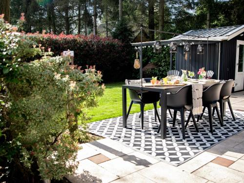 a table and chairs on a patio in a garden at Stayatsas Tiny House Julia in de bossen op de Veluwe! in Epe