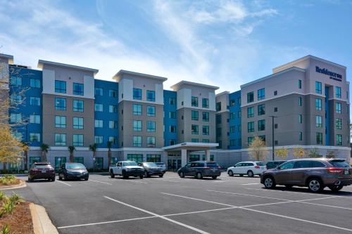 a parking lot with cars parked in front of a building at Residence Inn by Marriott Fort Walton Beach in Fort Walton Beach