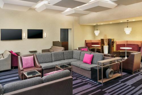 sala de estar con sofás, sillas y TV en Courtyard by Marriott New York JFK Airport, en Queens