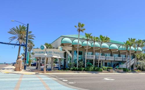 a building with palm trees in front of a street at Boardwalk Inn and Suites in Daytona Beach