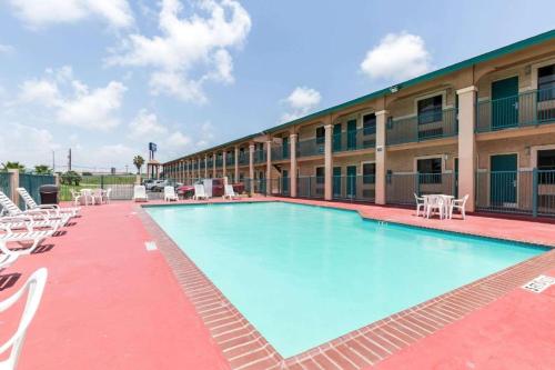 a swimming pool at a hotel with chairs and a building at The Residency Inn in Galveston