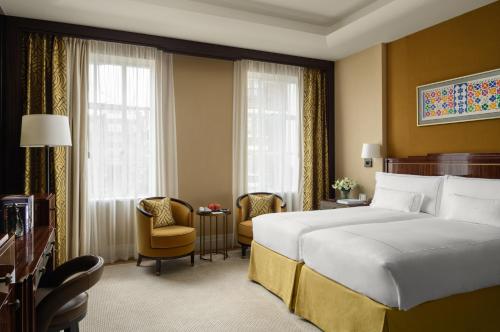 a hotel room with a bed and a chair at The Beaumont Mayfair in London