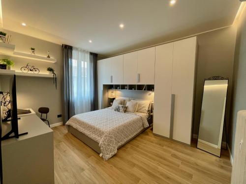 Luxury Downtown - Milan MF Apartments في ميلانو: غرفة نوم بسرير ودواليب بيضاء