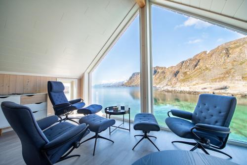 Zimmer mit einem großen Fenster mit Stühlen und einem Tisch in der Unterkunft Lofoten Waterfront luxury lodge in Ballstad