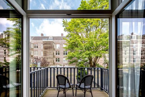 two chairs on a balcony with a view of a building at Hotel Atlantis Amsterdam in Amsterdam