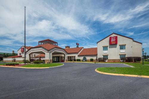 een hotel met een bord aan de kant van een weg bij Red Roof Inn PLUS+ & Suites Knoxville West - Cedar Bluff in Knoxville