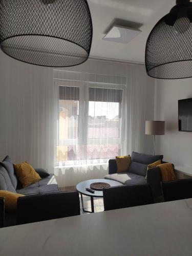 a living room with two couches and a table at Apartman Waldy in Osijek