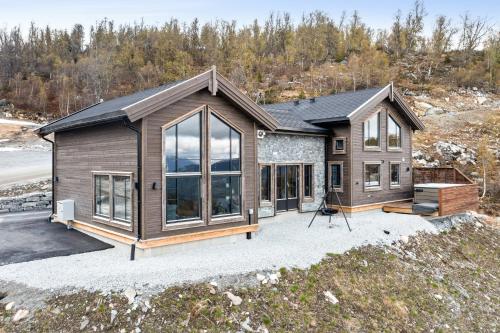 uma casa com muitas janelas numa entrada em Rindabakkane Lodge em Sogndal