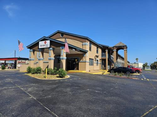 a building with two american flags in a parking lot at The Residency Inn in Galveston