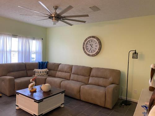 a living room with a couch and a clock on the wall at The Pelican’s Nest in Panama City Beach