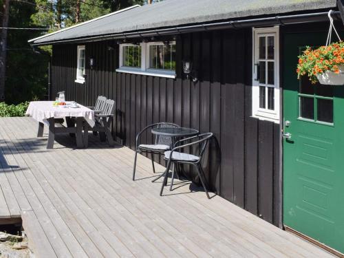 a black shed with a table and chairs on a deck at Holiday home Halden IV in Halden