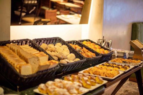 a buffet filled with different types of bread and pastries at My Story Hotel Tejo in Lisbon