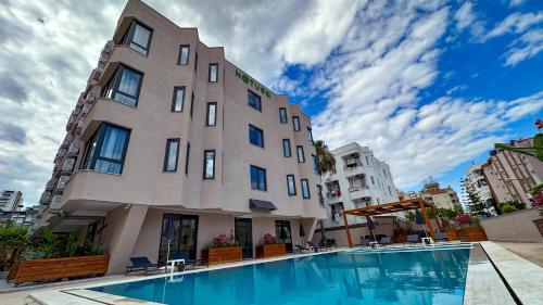 um edifício com piscina em frente a um edifício em Notus Suites em Antália