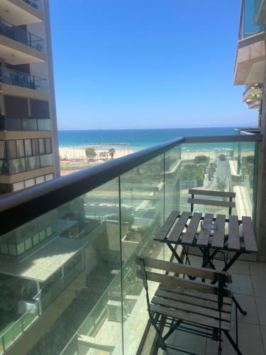 two benches on a balcony with a view of the ocean at Mediterranean Sea View in Ashqelon