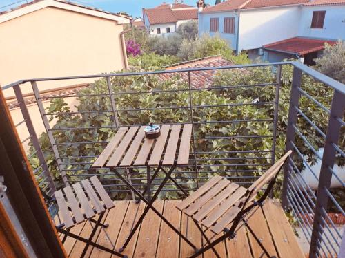 un balcone con 2 sedie e un tavolo su una terrazza di Guests house DaLi a Rovigno (Rovinj)