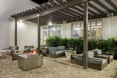 eine Terrasse mit Sofas und einer Feuerstelle in der Unterkunft Hilton Garden Inn Miami Dolphin Mall in Miami