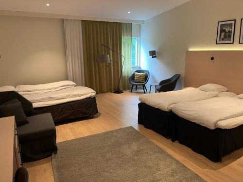 a hotel room with two beds and a chair at RC Hotel Sport's & Business in Jönköping