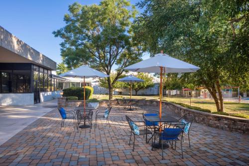 een groep tafels en stoelen met parasols bij DoubleTree by Hilton Cherry Hill Philadelphia in Cherry Hill