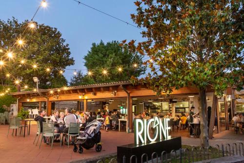 un gruppo di persone seduti ai tavoli fuori da un ristorante di hu Roma Camping In Town a Roma