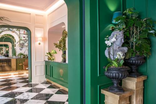 a hallway with green walls and a vase with flowers at Hotel La Gemma in Florence