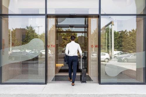 a man walking out of a revolving door at Moov Hotel Lisboa Oriente in Lisbon