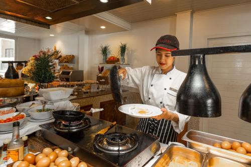 uno chef prepara i pasti in una cucina di Centara Kata Resort Phuket a Kata Beach