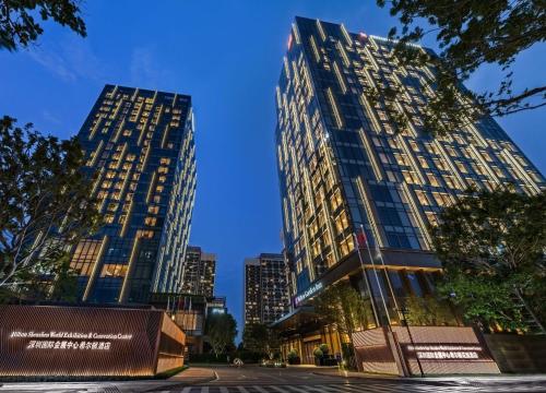 two tall buildings in a city at night at Hilton Shenzhen World Exhibition & Convention Center - Only 5 minutes' walk to WECC in Shenzhen