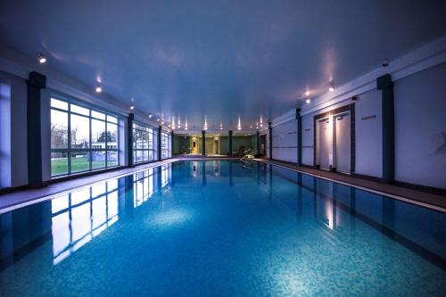 チェルトナムにあるDoubleTree by Hilton Cheltenham-Cotswoldsの建物内の青い水のスイミングプール